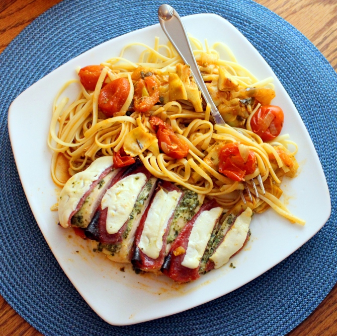 Chicken Antipasti. Baked chicken smothered in pesto topped with salami and mozzarella.  This delicious entree is also complimented with a cherry tomato and artichoke sauce! Yum!  Small Town Girl Blog.